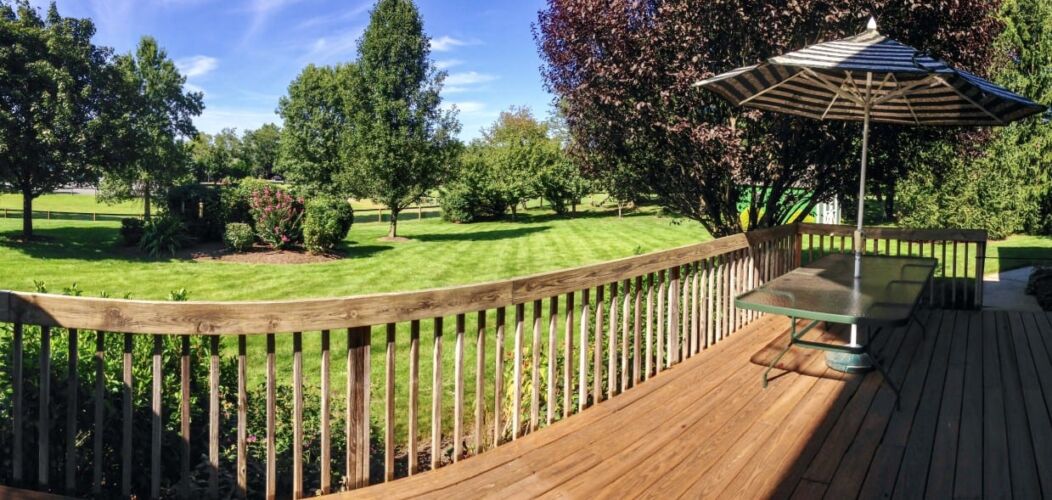 backyard-and-deck-with-table-and-umbrella-on-a-sunny-summer-day_t20_nRByYK
